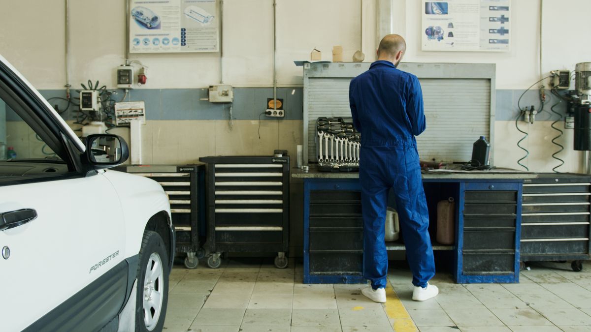 Mecánico revisando el motor de un auto en un taller antes de la revisión técnica